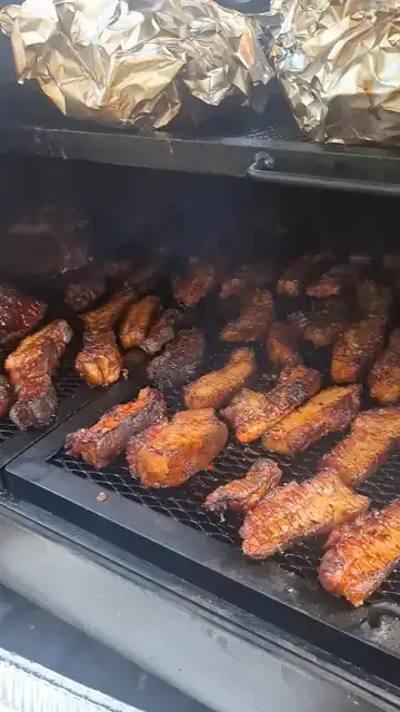Glazed pork belly strips caramelising on the smoker grates