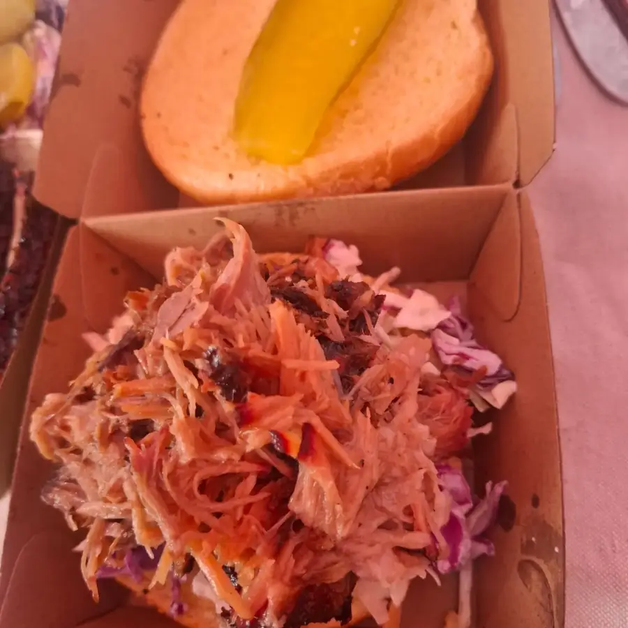Smoked pulled pork roll on creamy slaw, with a pickle on the lid